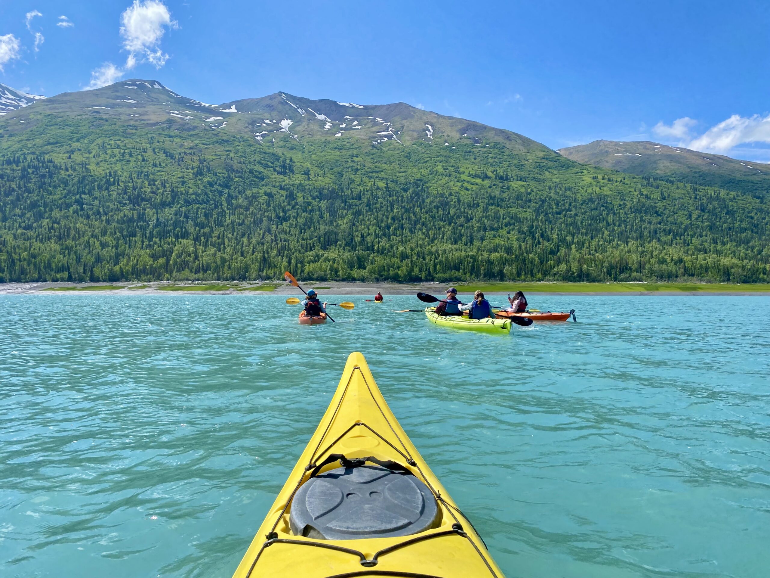 People kayaking on a the ocean at an all incllusive adults resort with sunshine and blue water.