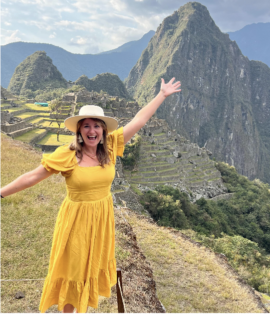 Jessica Frey in yellow dress posing at Machu Picchu
