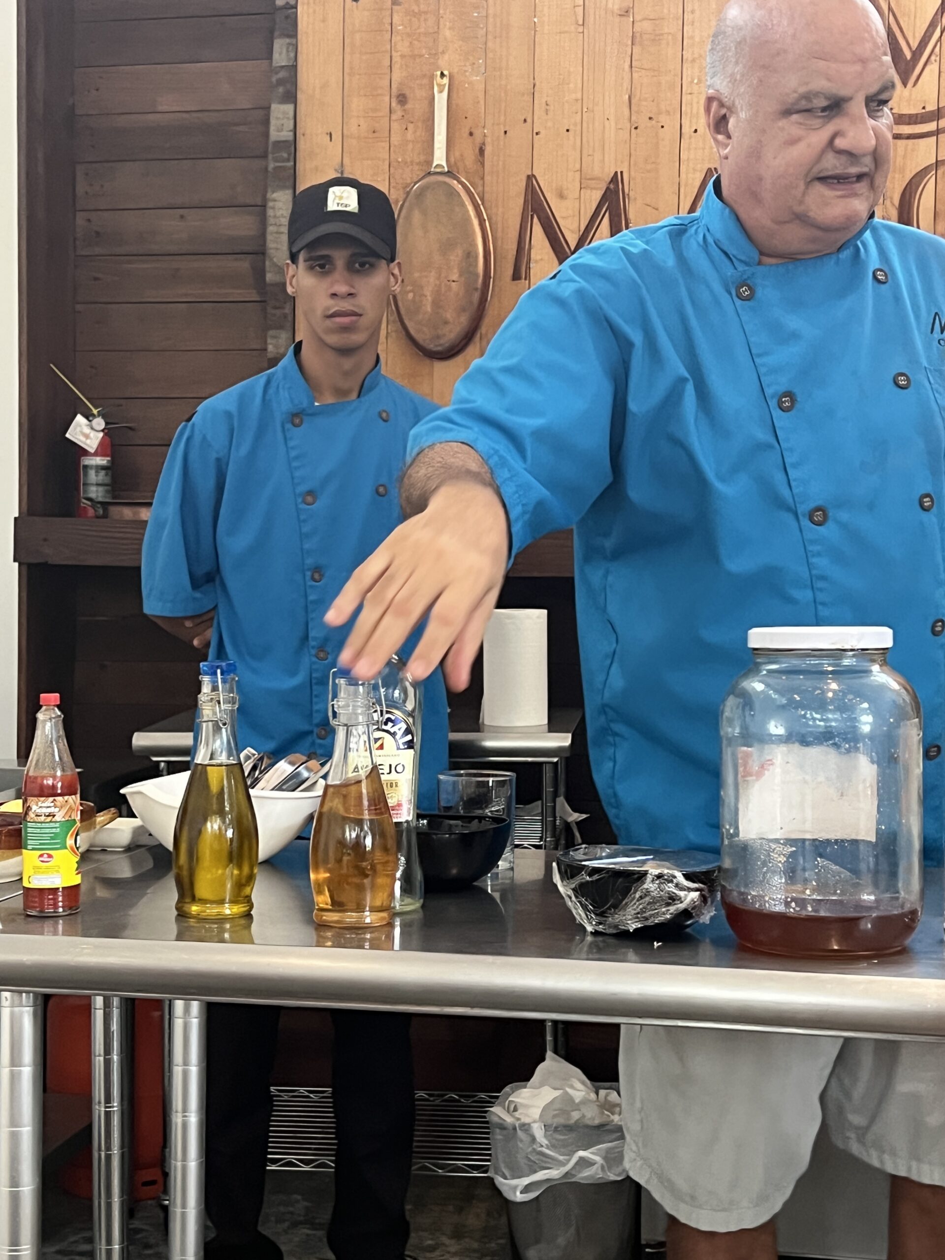 cooking class outdoors in tropical setting Chef of Richard Branson preparing a meal in an outdoor kitchen in the Dominican Republic surrounded by tropical plants